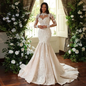 Elegant champagne and white mermaid bridal gown with long sleeves and lace train