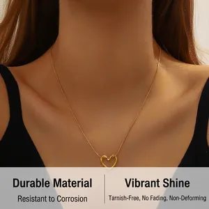 Detail view of a gold hollow heart pendant on a delicate snake chain for women