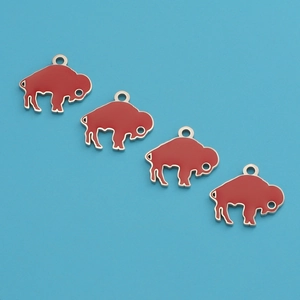 Detail of four red enamel buffalo charms with silver edges on a blue background
