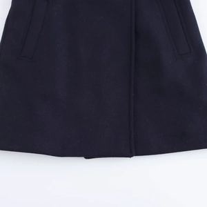 Macro view of navy blue wool blend coat showing high-quality fabric texture and weave
