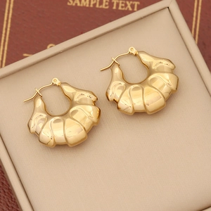 Golden croissant dome hoop earrings with vertical ribbed texture in stainless steel