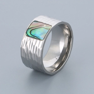 Detail of wide stainless steel ring with hammered texture and square abalone shell inlay