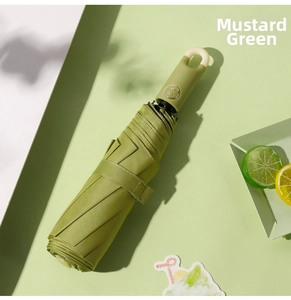 Close-up of mustard green folding umbrella with unique ring handle and auto button