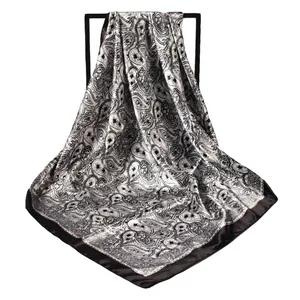 Detailed close-up of the black and white Paisley print on a silk-like square scarf