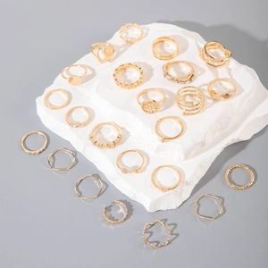 Close-up of 20-piece gold ring set featuring heart and snake motifs on stone pedestals