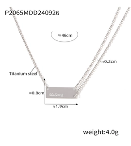 Detail view of rectangular titanium steel pendant with custom engraving on silver chain