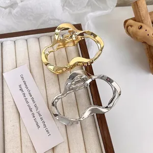 Irregular cloud-shaped liquid metal hair claws in glossy gold and silver finish