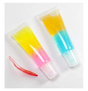 Close-up of glitter gradient lip gloss tubes in yellow, pink, and blue shades