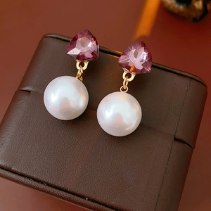 Détail de boucles d'oreilles vintage avec pierres violettes et perles sur cuir