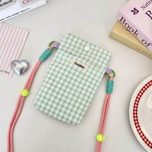 Detail of green plaid fabric phone bag with pink rope strap and adjustable buckle