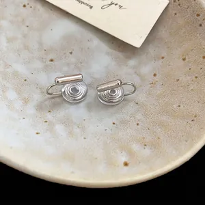 Minimalist silver geometric ear clip converter with comfortable silicone pad on ceramic plate