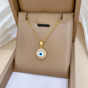 Macro shot of gold Evil Eye necklace with blue enamel and sparkling pave crystals