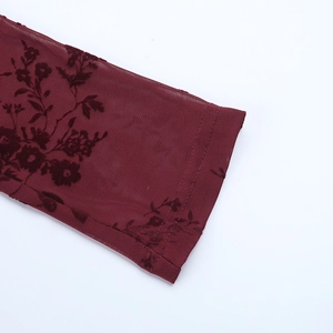 Gros plan détaillé sur la manche en tulle bordeaux aux motifs floraux floqués en 3D