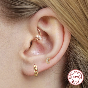 Macro-opname van gouden 925 sterling zilveren maan oorbellen en ketting cuff op het oor