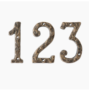 Detail of rustic cast iron numbers 1, 2, 3 with antique bronze finish and hand-hammered texture