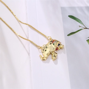 Detail of gold elephant necklace featuring multi-colored rainbow zircon inlay on white books