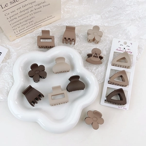 3-piece set of brown matte claw clips in flower and geometric shapes on a flower tray