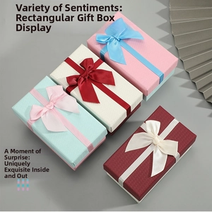 Detail view of rectangular gift boxes with woven texture and satin ribbon bows