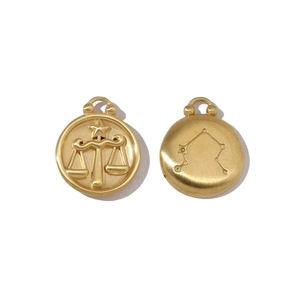 Detailed macro view of gold Libra zodiac pendant with constellation and star map engraving