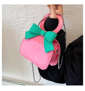Detail of pink and green heart-shaped mini bag with silver chain strap and round handle