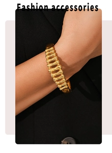 Detail of gold-plated fishbone texture bracelet on wrist with fashion accessories text