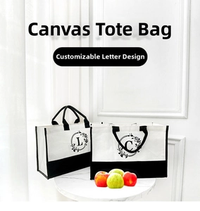 Detail of white and black canvas tote bag with custom floral letter print on marble table