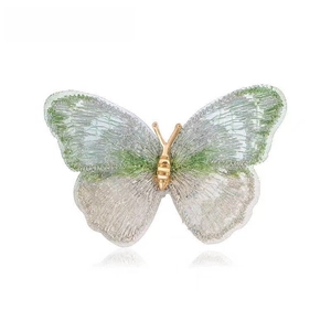 Elegant butterfly brooch with green gradient textile wings and golden metal body