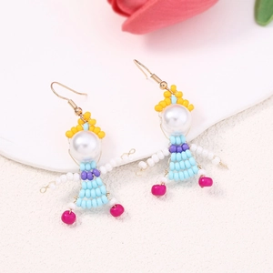 Detail of handmade beaded doll earrings featuring imitation pearls and blue skirts