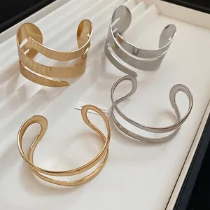 Minimalist double-layered gold and silver geometric cuffs in a spiral open design