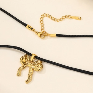 Detail of 18k gold bow pendant with black cord and S-STEEL engraved lobster clasp