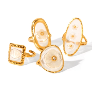 Set of four 18K gold plated stainless steel rings with white flower and shell designs