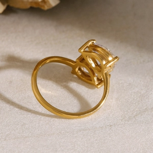 Detailed close-up of gold-plated stainless steel ring with claw-set cubic zirconia stones