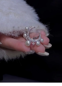 Macro shot of silver crescent ring featuring white pearls and micro-pave zircons