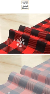 Close-up of snowflake printed plaid fabric showing red-black and pink-gray textures
