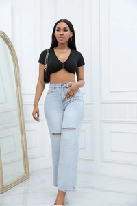 Detailed shot of light blue high-waisted denim jeans featuring stylish distressed rip details