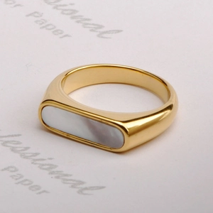 Macro shot of gold-plated stainless steel ring featuring rectangular white shell inlay