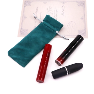 Green velvet drawstring gift pouch for jewelry and lipsticks on a white background