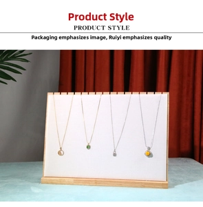 Detail of four unique jewelry necklaces hanging on a white faux leather display stand