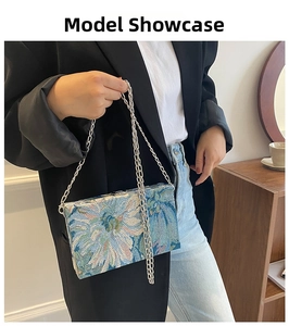 Detailed close-up of vintage blue and white floral embroidery on a chain crossbody bag