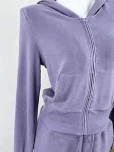 Detail of purple zip-up hoodie featuring ribbed cuffs and soft fabric texture