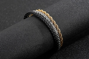 Detail of multi-layer bracelet with gold rope chain, silver weave, and black leather band