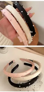 Detail of satin padded headbands with pearls and crystals in black, beige and pink colors