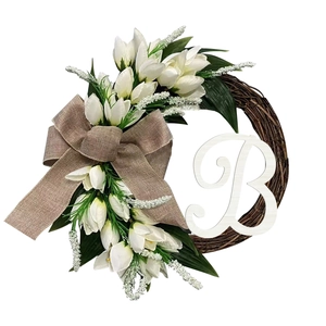 Detailed view of the artificial white tulip wreath with beige burlap bow and white letter B