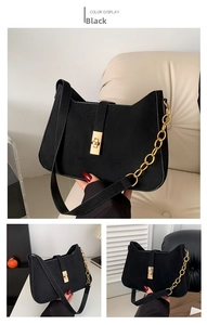 Detail of black matte shoulder bag featuring gold square buckle and chain strap