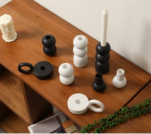 Detailed view of matte black and white ceramic candle holders on a wooden shelf