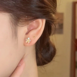 Elegant gold flower stud earrings with zircon crystals shown on model in profile view