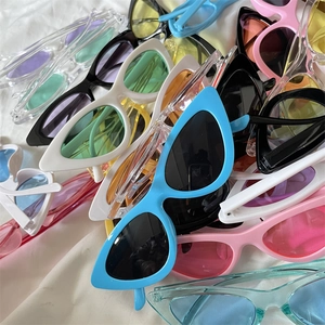 Flat lay of colorful cat eye sunglasses in jelly colors on white fabric background
