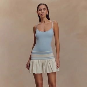 Détail de la robe courte moulante bicolore bleu et blanc avec une jupe plissée