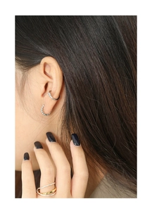 Minimalist silver ear cuff and two-tone layered ring set worn by a female model