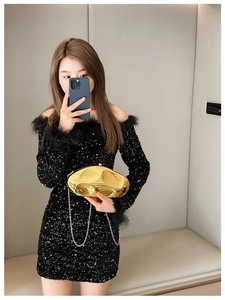 Close-up of golden irregular geometric metal clutch bag with a delicate chain strap